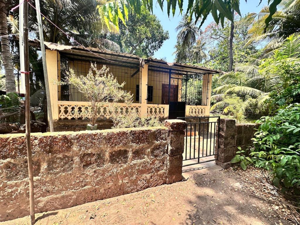 a house with a gate in a garden at Peaceful Stay in Malvan