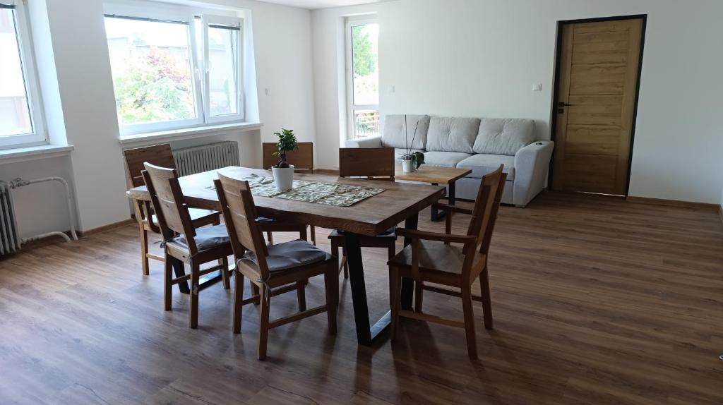 a dining room with a table and chairs and a couch at Na břehu Olše in Český Těšín