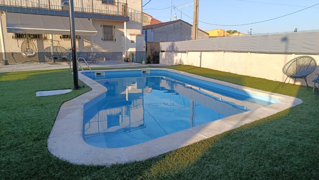 a small swimming pool in the grass with a building at Casa el moral 2 in Castillejo de Martín Viejo