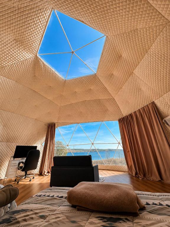 a bedroom with a large window in the ceiling at Baddeck Domes in Baddeck