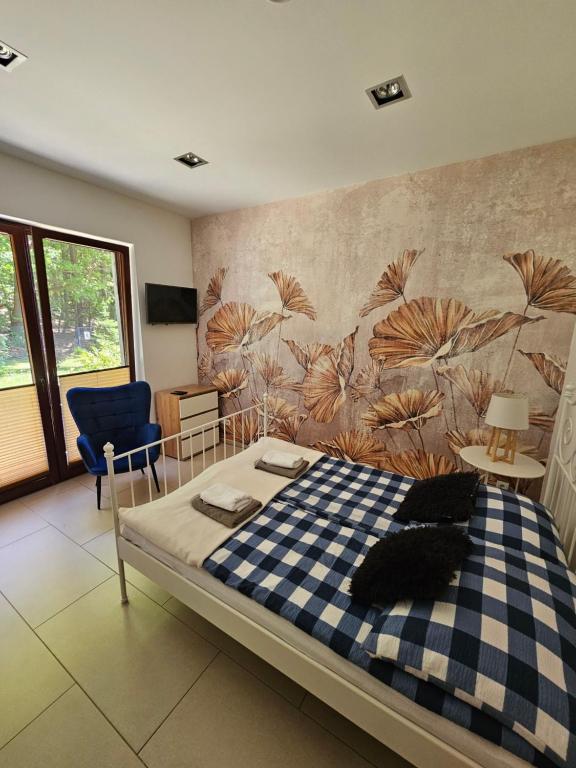 a bedroom with a bed and a wall with a mural at Apartamenty Wisełka in Wisełka