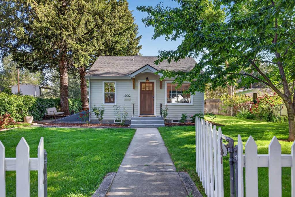 a white picket fence in front of a white house at The McKinley Cottage in Boise
