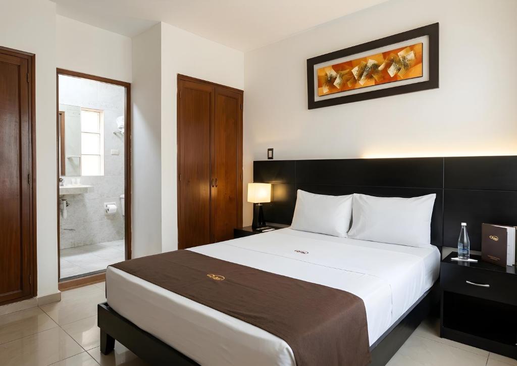 a bedroom with a large bed and a bathroom at Deville Inn in Lima