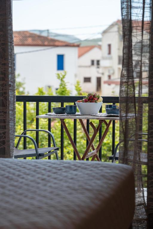 a table with a bowl of flowers on a balcony at Tsimiklis Apartments in Finikounta