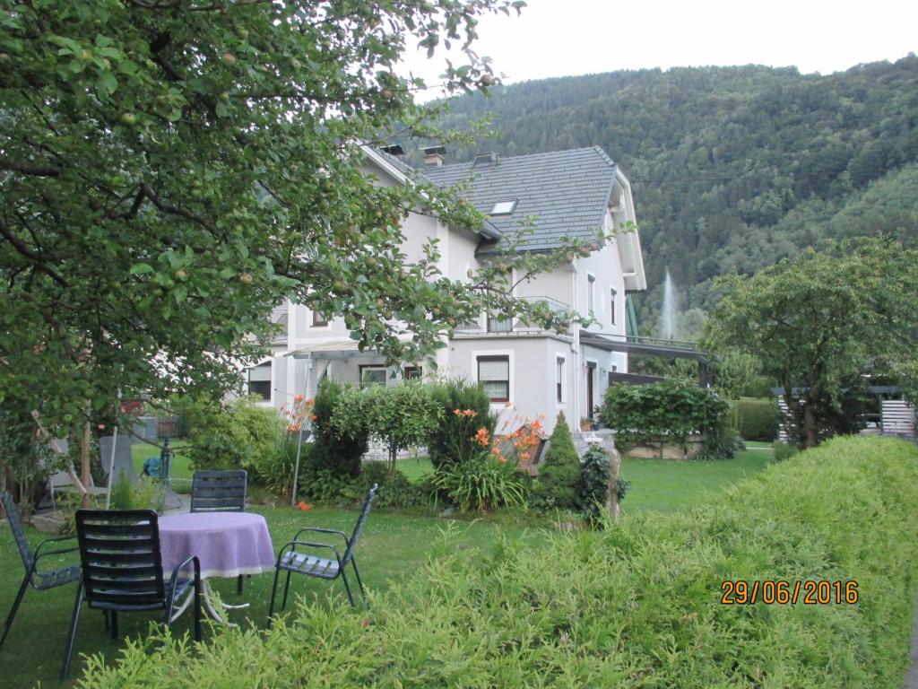 dom ze stołem i krzesłami na dziedzińcu w obiekcie Ferienwohnung Steinwender w mieście Döbriach