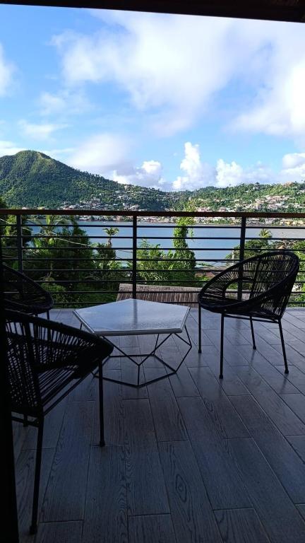 a table and two chairs on a deck with a view at Résidence LE MÄYSA in Sada