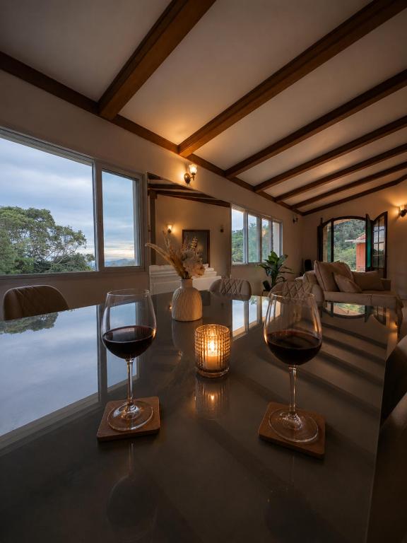 two glasses of wine sitting on a table in a room at Refúgio em Atibaia in Atibaia