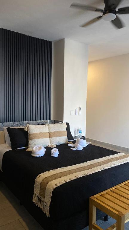 a bedroom with a large bed with a ceiling fan at PELÍCANOS Hotel & Beach Club in El Zapote