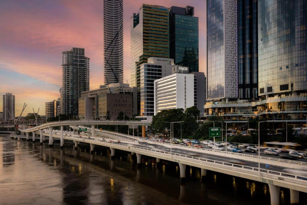 a bridge over a river in a city with buildings at voco Brisbane City Centre by IHG in Brisbane