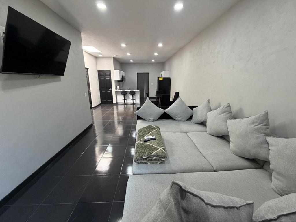 a living room with a couch and a flat screen tv at TinyHouseMX2 Comodidad, lujo y playa que se disfruta in Barre De Navidad