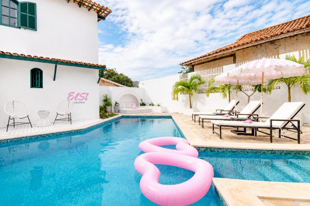 a swimming pool with a pool noodle in the middle of a house at Elsi Pousada in Búzios