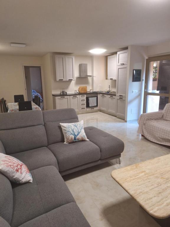 a living room with a couch and a kitchen at La taverna del puntone in Puntone di Scarlino
