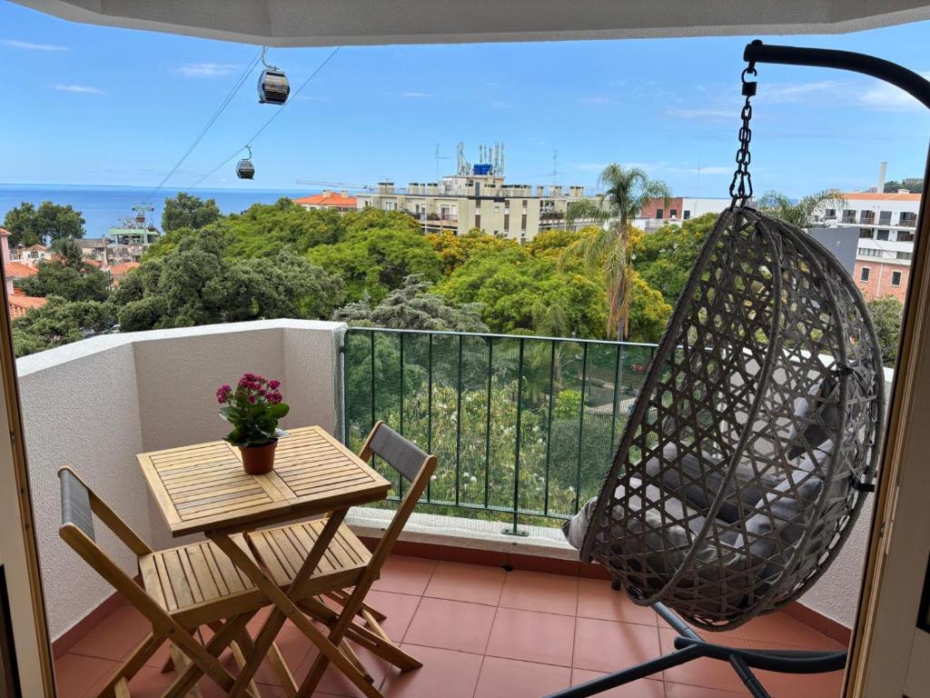 a balcony with a hammock and a table and chair at Madeira Ocean View in Funchal