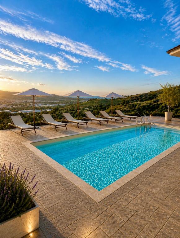 a swimming pool with chairs and umbrellas on a building at Tenuta Piccioni Relais,Pool and Spa in Colonnella