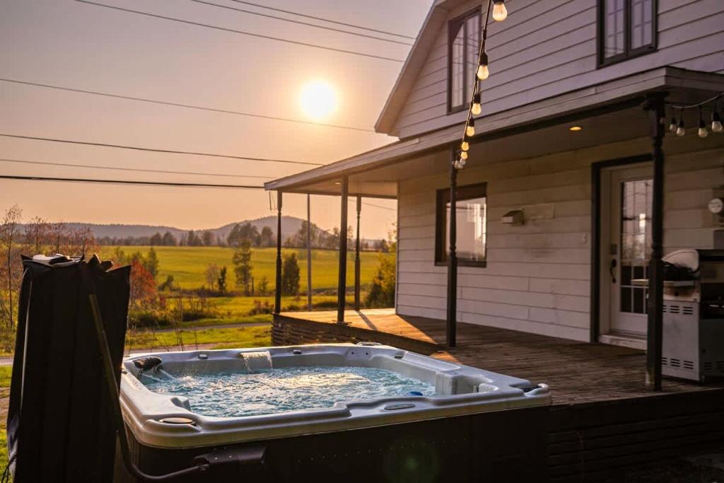 a hot tub on the back of a house at Rustic Chalet Hideaway - Hot Tub & Trail Access in Saint-Léonard-de-Portneuf