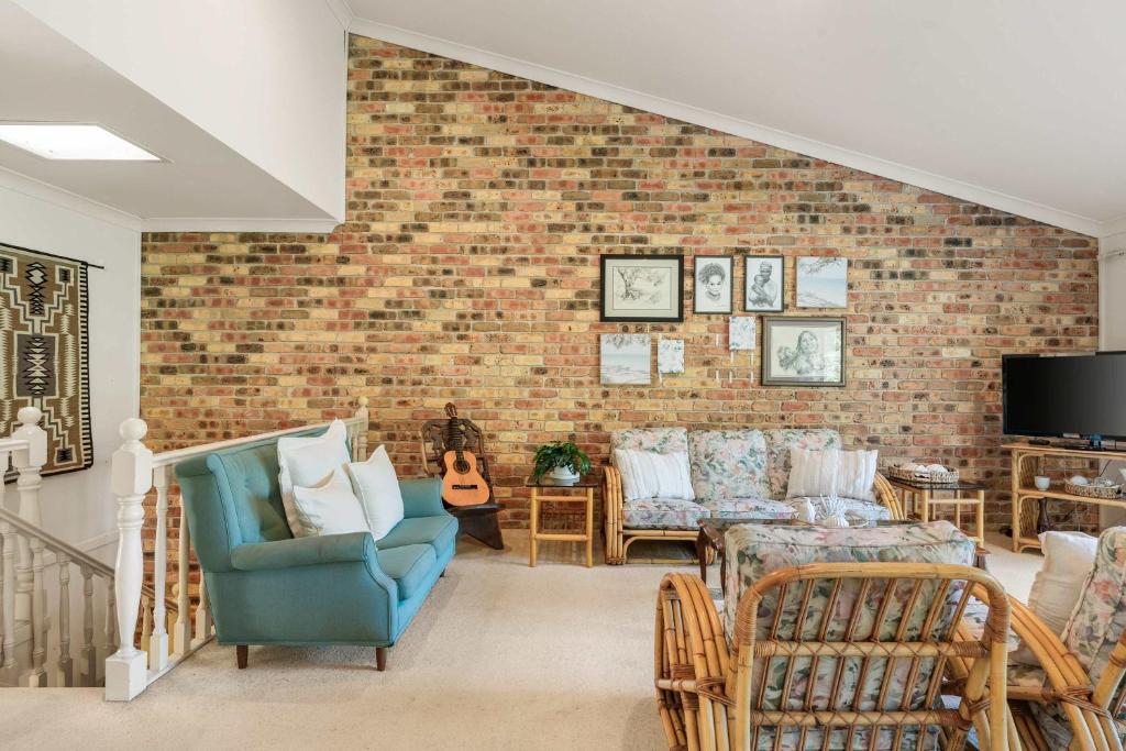 a living room with a brick wall at Harbour Creek in Ulladulla