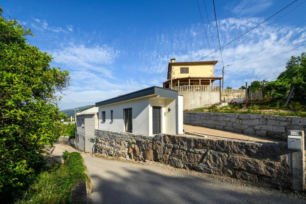 a house on a hill with a stone wall at Terreiro da Serra in Rio Caldo