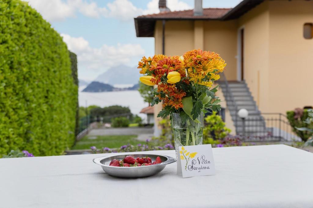 a vase filled with flowers next to a bowl of berries at Villa Sanziana in Menaggio