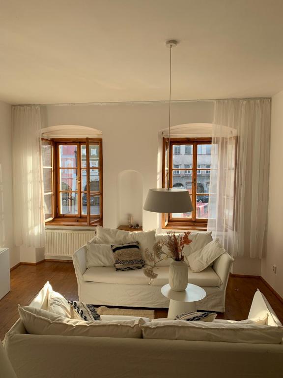 a living room with a white couch and two windows at Prázdninový dům Litomyšl 79 in Litomyšl