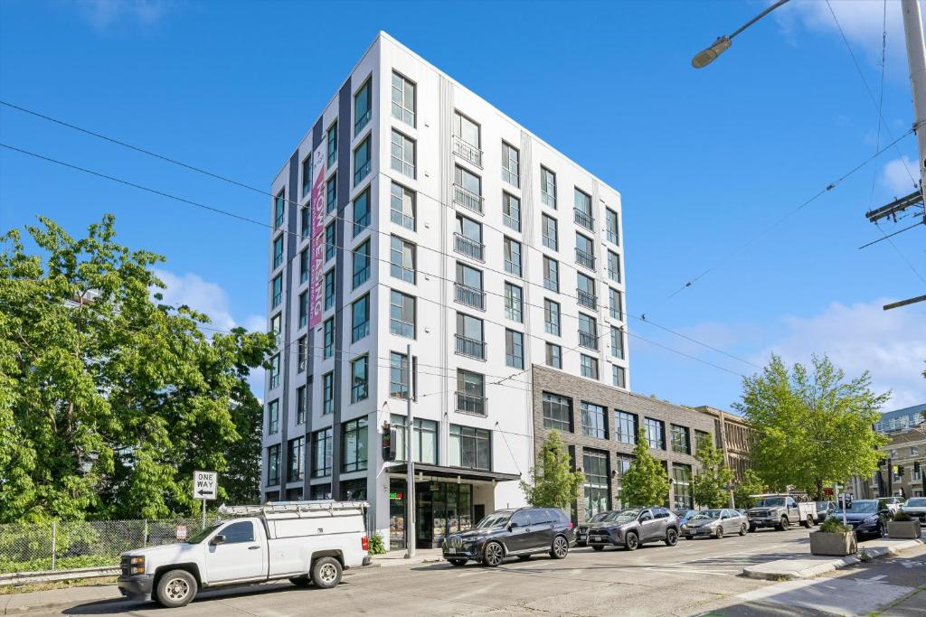 a white building with cars parked in a parking lot at Kasa Capitol Hill Seattle in Seattle