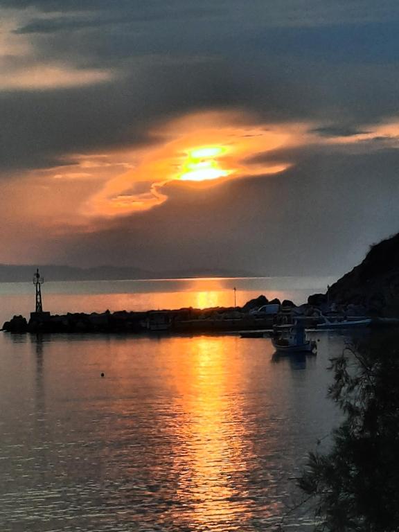 a sunset over a body of water with the sun setting at Sunset Hotel Kini Beachside in Kini