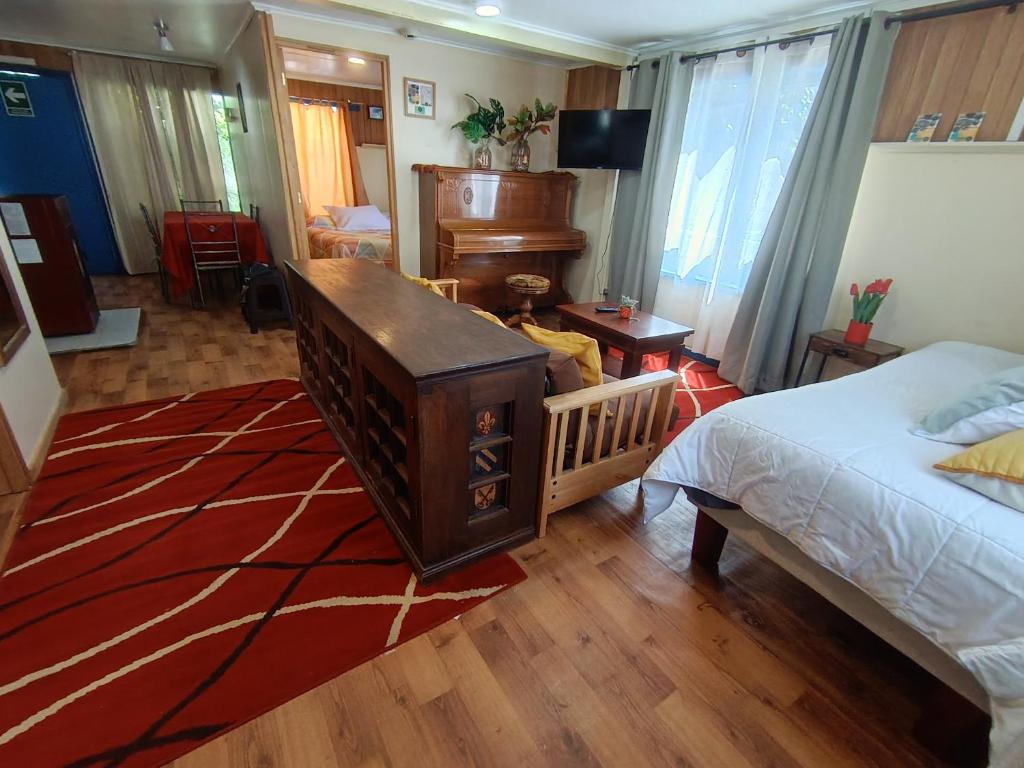 a bedroom with a bed and a desk and a piano at Cabaña Aldea 31 in Coihaique