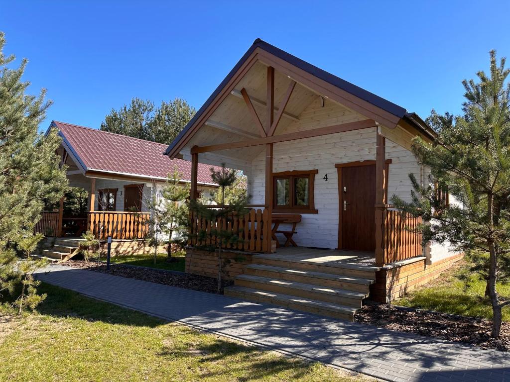 a small house with a porch and a deck at Pięć Sosen in Wiele