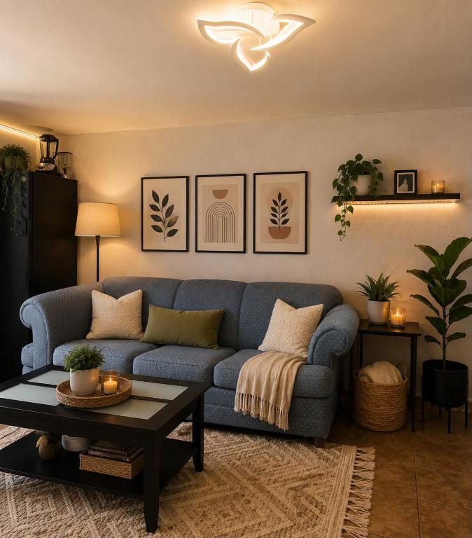 a living room with a blue couch and a table at Acogedor estudio cerca del aeropuerto in Tijuana