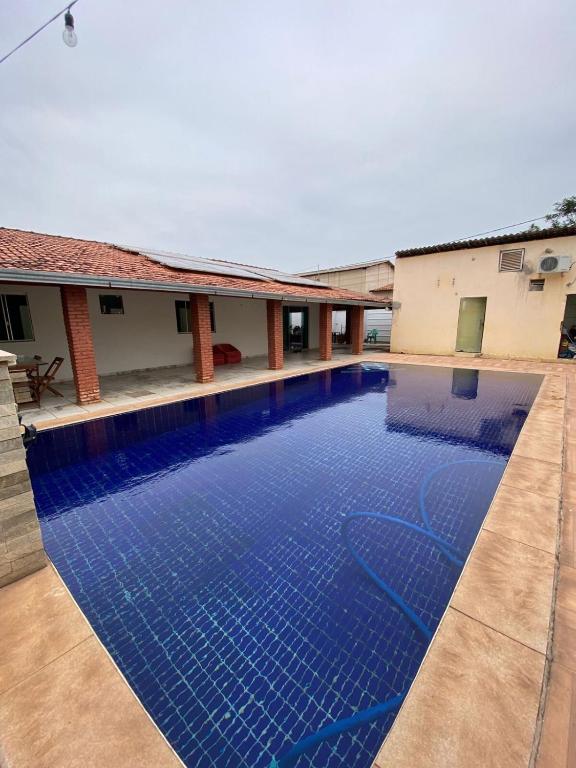 a large blue swimming pool next to a building at Casa com piscina in Imperatriz