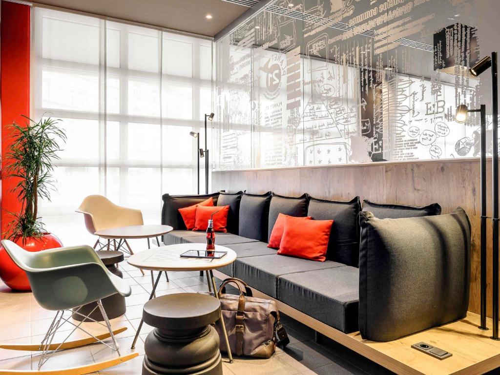 a living room with a couch and a table and chairs at ibis Hotel München City in Munich