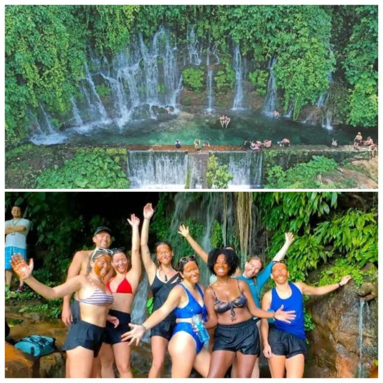a group of people standing in front of a waterfall at Accomodation Hostal El Pacifico in Juayúa