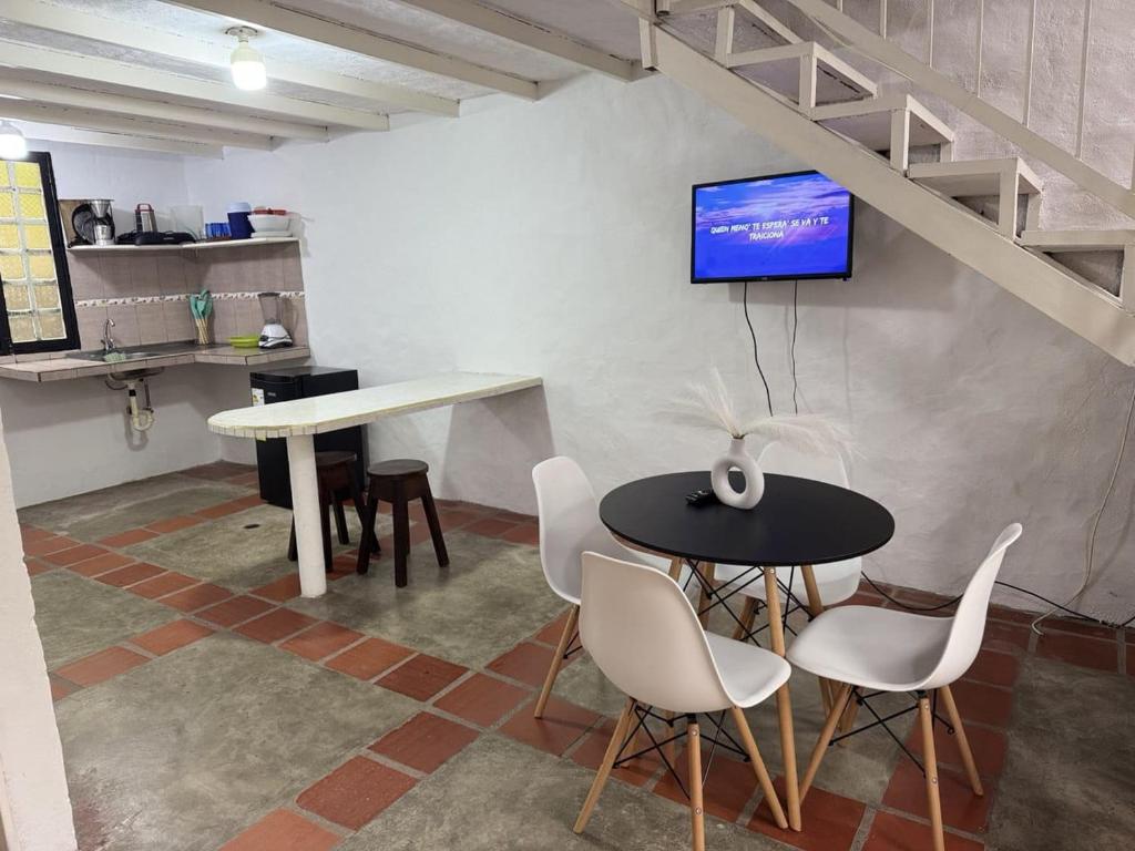 a dining room with a table and chairs and a tv on the wall at Cabaña destino 11 in Mérida