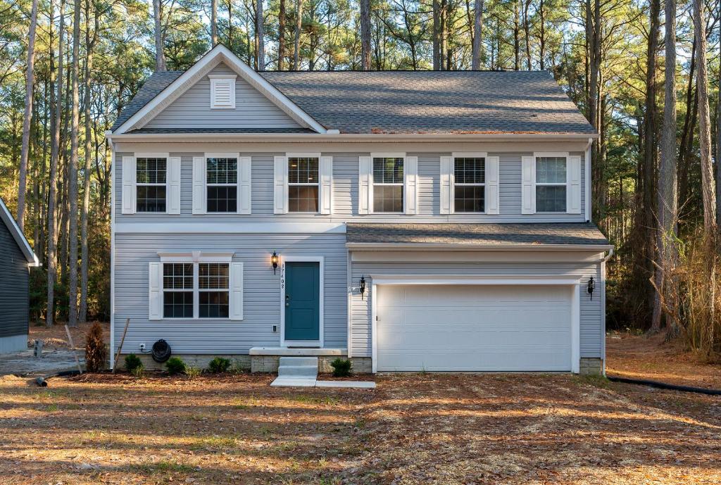 a white house with a garage at Hidden Gem in Greenbackville