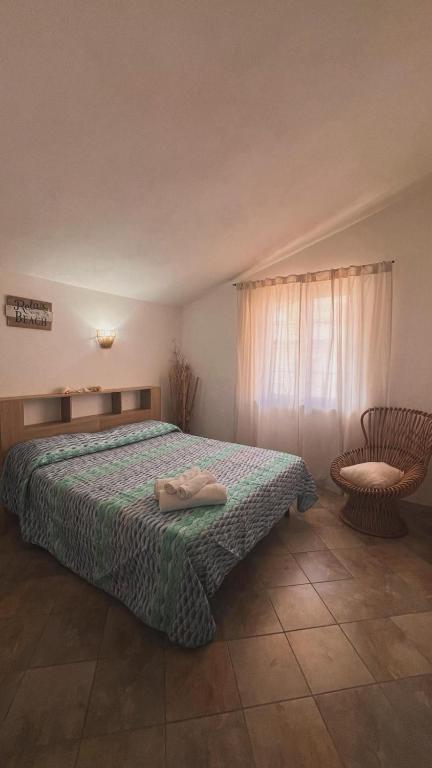a bedroom with a bed and a chair at House Mimma Tropea in Santa Domenica