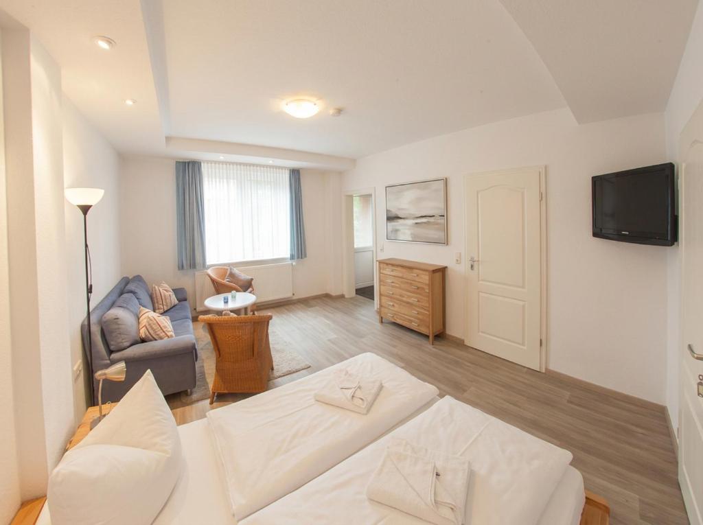 a living room with a couch and a tv at Apartment Leefke im Dangaster Nest in Varel