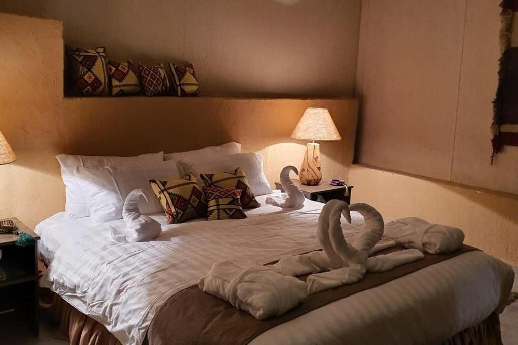a bed with two swans made out of towels at مخيم سياحي in Disah