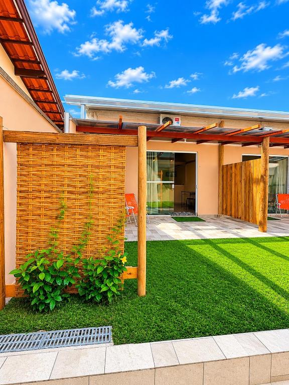 a backyard with a fence and a lawn at Chalés & Suítes Praia Barequeçaba I Cozinha Compacta in São Sebastião
