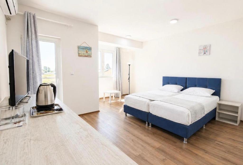 a bedroom with a bed and a flat screen tv at Mia Apartment in Veles