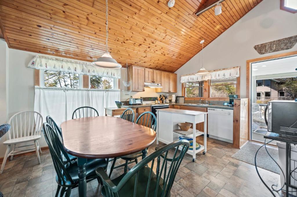 a kitchen with a wooden ceiling and a table and chairs at Les Bon Temps in Birch Town