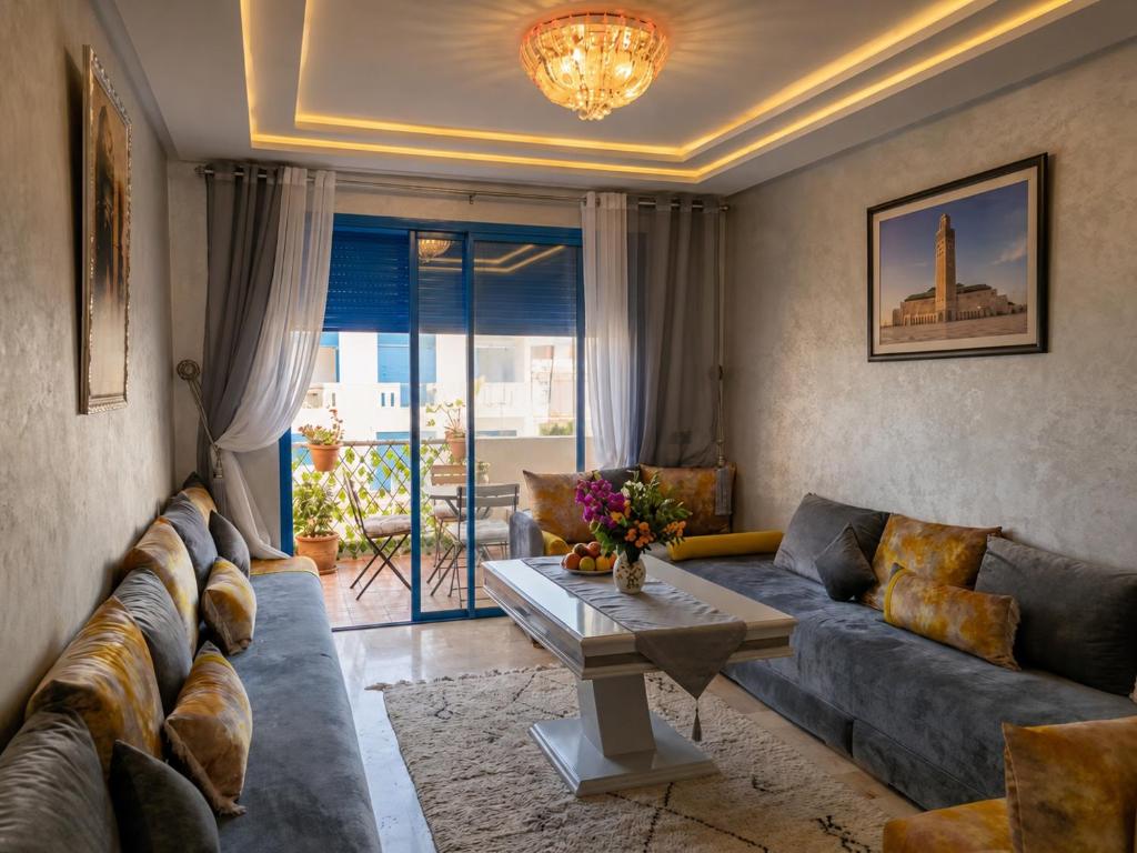 a living room with a couch and a table at Perla Andalusia Bright 2BR Near Beach & Pool in Mansouria