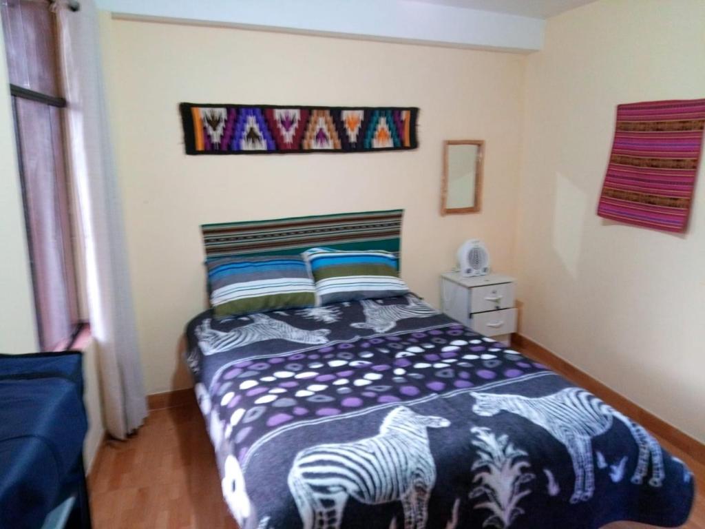 a bedroom with a bed with a zebra blanket at Hatun Apu Center Casa de Ayahuasca y San Pedro in Pisac