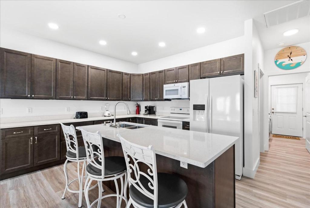 a kitchen with a white counter top and wooden cabinets at Lily Pad 2 in Birch Town
