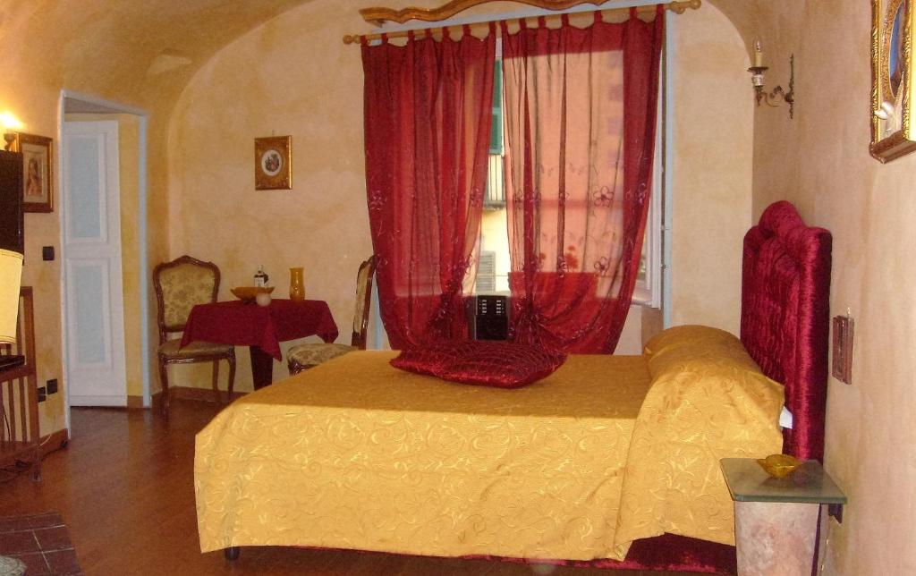 ナポリにあるB&B Carolina Plebiscito R.のベッドルーム1室(赤いカーテンと窓付きのベッド1台付)