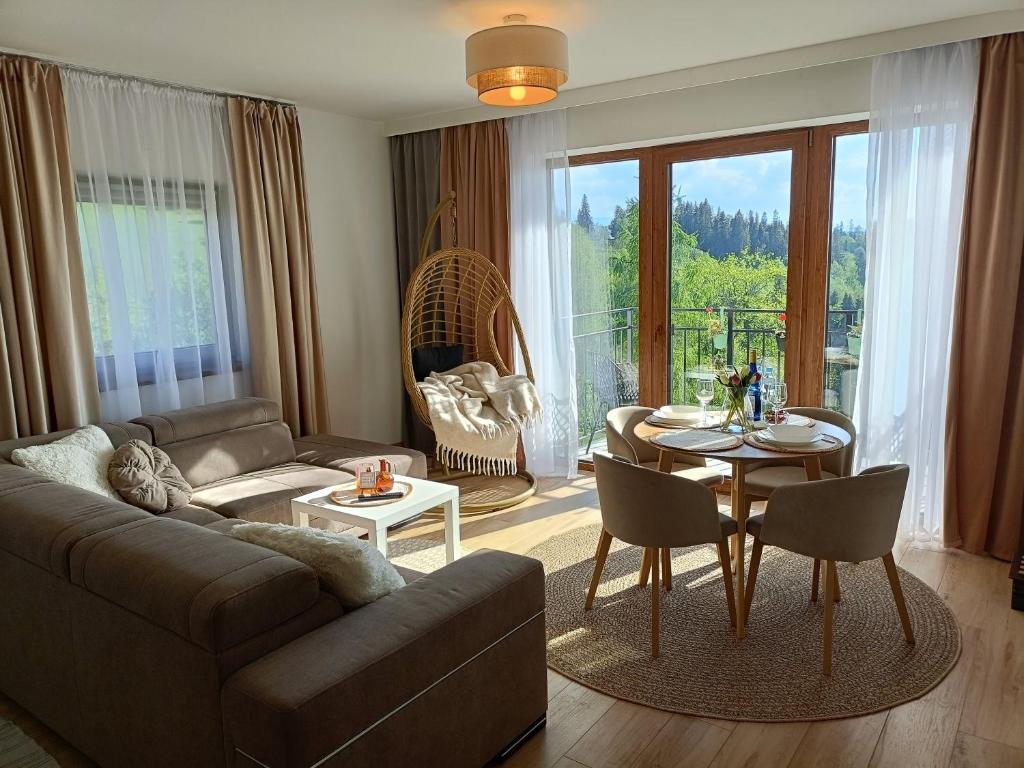 a living room with a couch and a table at Apartament Dwa Słońca in Gliczarów