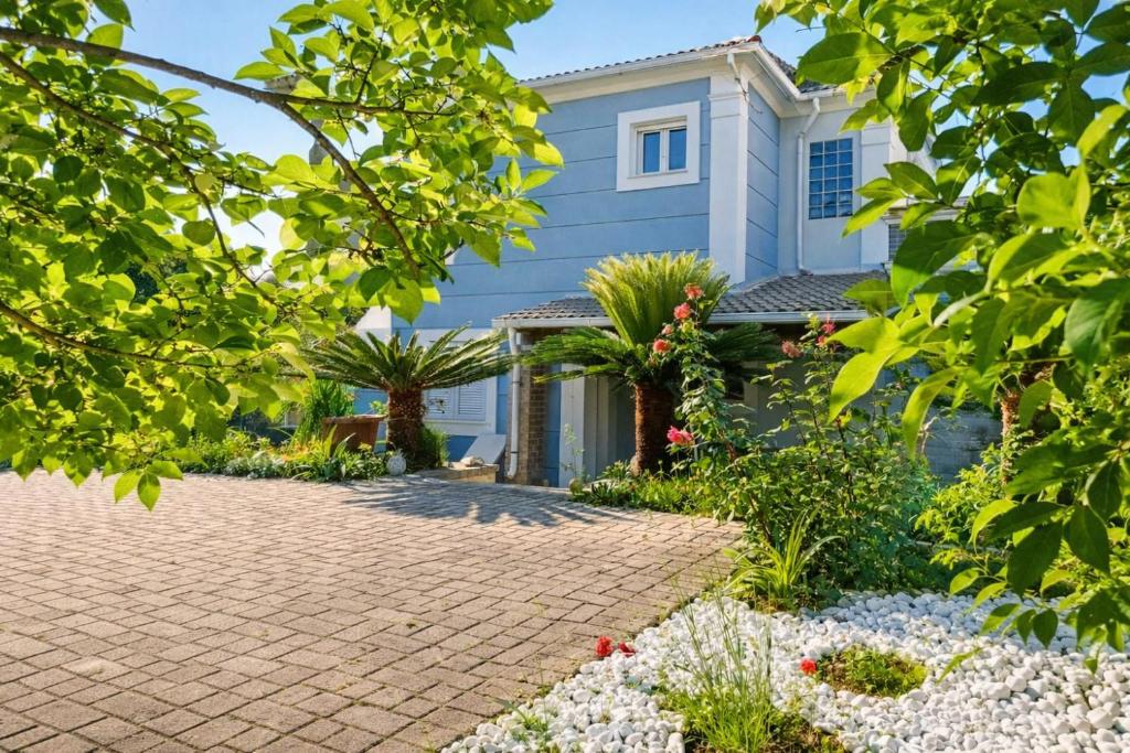 a house with a brick driveway at Villa Nirvana - Sea View Maisonette in Roda, Offering Tranquility and Comfort on the Enchanting Northern Coast of Corfu in (( Litherés ))