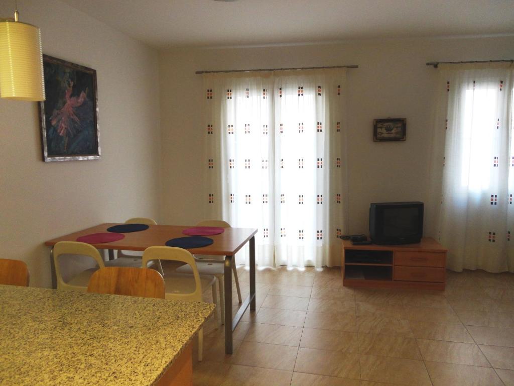 a kitchen and dining room with a table and a tv at Apartaments Bonaventura 24 in Sitges