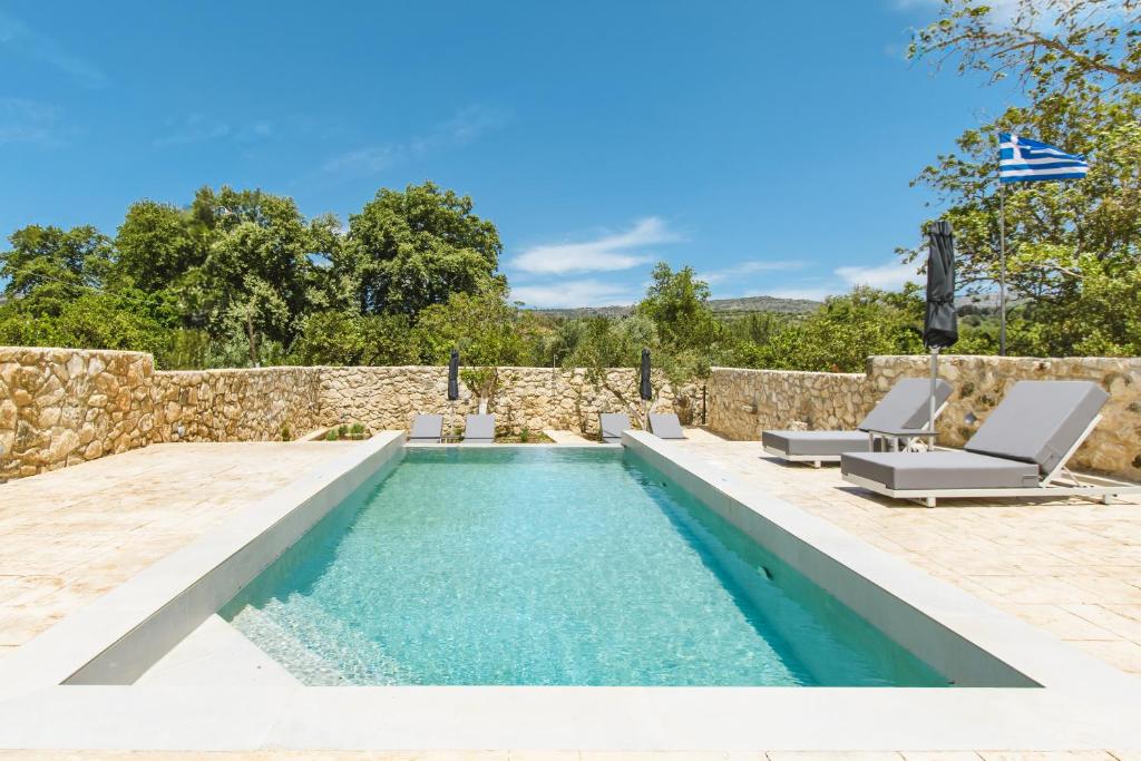 a swimming pool with lounge chairs and a swimming pool at Archontiki Elite Villa - Private Pool, Chania in Vryses