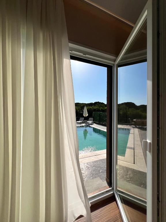 a sliding glass door with a view of a swimming pool at Sunset Aura Riverside Villa & Pool in Draç