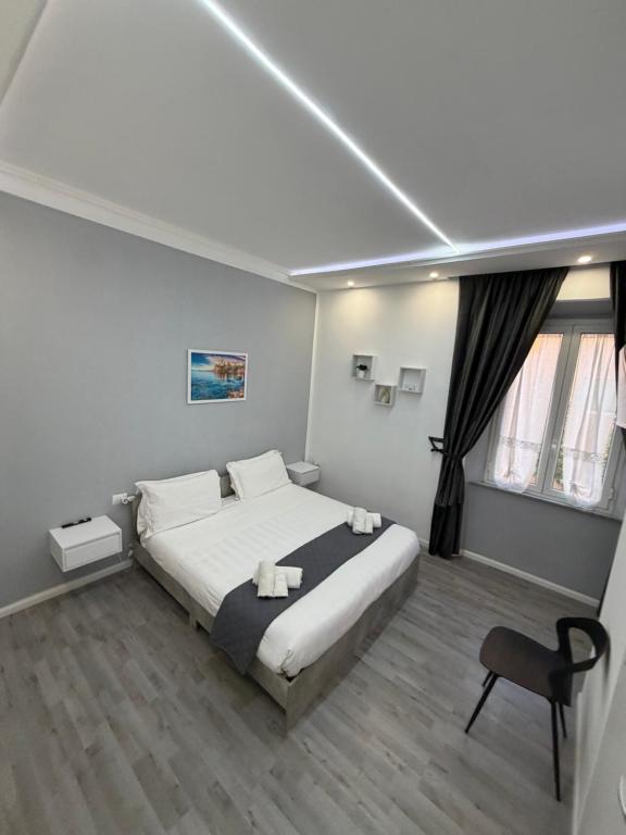 a bedroom with a large bed and a chair at Residenza Delle Isole in Piombino