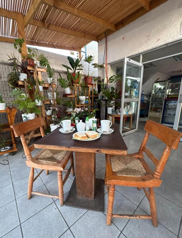 a wooden table with a plate of food and two chairs at ROSETTA Café & Camas in La Serena